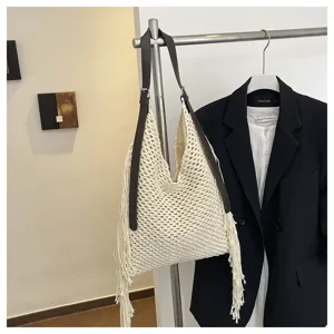 Gros plan d'un sac cabas hobo tissé à la main avec franges beige et lanières marron.
