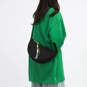 Black nylon crescent crossbody bag with grid pattern and stylish braided strap accessory for women.