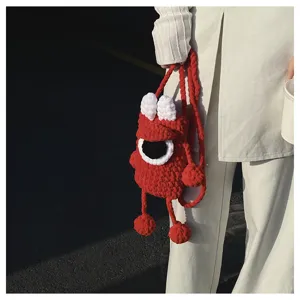 Handmade red knit monster phone bag detail view, stylish cross-body crochet mini bag style.