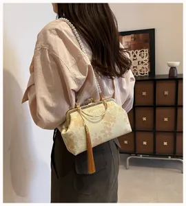 Detaillierte Ansicht der chinesischen Handtasche mit Blumenstickerei und Perlenriemen.