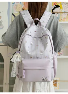 Detail view of light purple cute dog print backpack with lace pearl pendant and pockets.