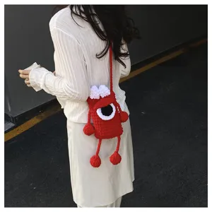 Handmade knitted red monster crossbody phone bag with cute big eye and funny dangling limbs.