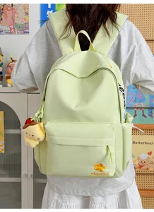 Close-up detail of the light green canvas backpack showcasing cute floral embroidery.