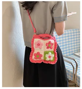 Primo piano dettagliato di una borsa a traccolina in crochet floreale multicolore.