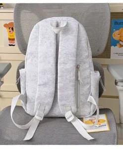 Backpack back detail showing grey nylon fabric, adjustable straps and side zipper pocket.