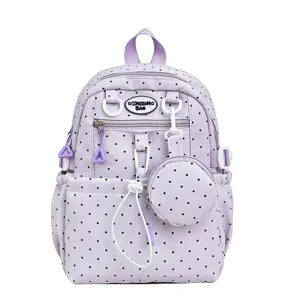 Vue rapprochée du sac à dos d'école à pois mauves avec une jolie petite pochette ronde.