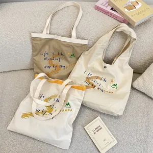 Casual large capacity canvas shoulder bag with aesthetic letter embroidery for daily use.