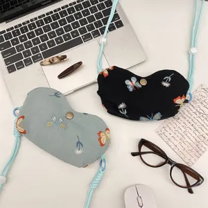 Detailansicht tragbarer bestickter Schmetterlings-Brillentaschen mit Umhängeband für Reisen.