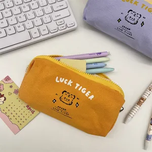 Cute yellow canvas pencil case with cartoon tiger print, ideal for stationery or makeup storage.