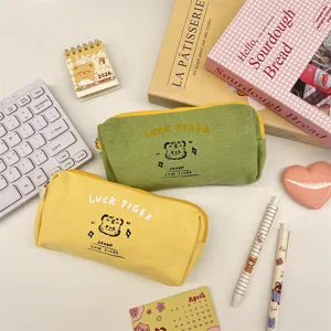 Cute canvas pencil pouch and stationery organizer yellow and green detailed desk view.