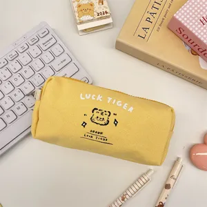 Detail view of yellow canvas pencil pouch with cute tiger graphic and text print.
