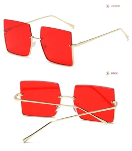 Gafas de sol cuadradas grandes con lentes rojas y montura de metal dorada para mujer.