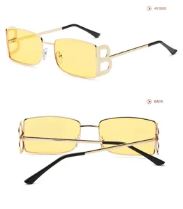 Vista detallada de gafas de sol vintage cuadradas de metal con lentes amarillas y patillas.