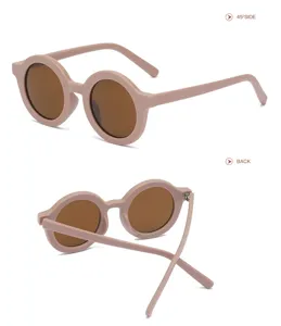 Vista dettagliata di occhiali da sole rotondi per bambini in rosa crema, stile chic.