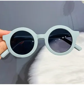 Close-up detail of the stylish matte light blue round frame sunglasses with dark gradient lenses.