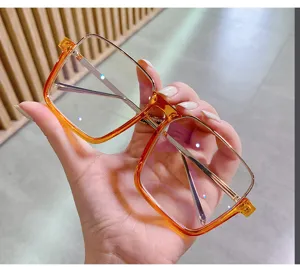 Vue de détail rapprochée de lunettes élégantes carrées orange dégradé à monture métal.