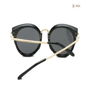 Vue détaillée de lunettes de soleil rondes noires élégantes avec branches dorées et design moderne.