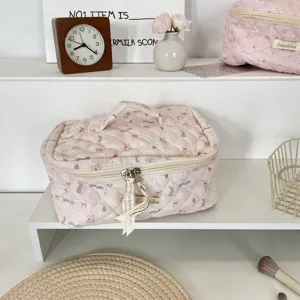 Pink quilted cosmetic bag detail view, showing soft fabric, cute cartoon print and durable zipper.