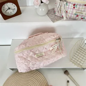 Quilted pink cosmetic travel bag detail showing cute rabbit pattern, zipper pull, and soft fabric.
