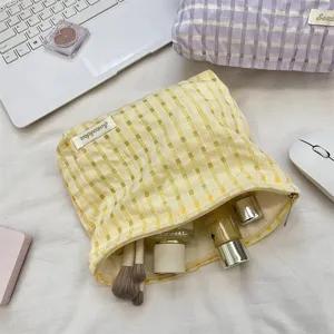 Yellow grid portable makeup bag, stylish cosmetic storage pouch for daily travel and organization.