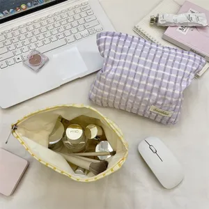 Detailed view of portable checkered cosmetic storage bag with zipper and neat flat lay setup.