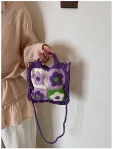 Primo piano dei dettagli della borsa a tracolla in maglia di fiori all'uncinetto colorata.