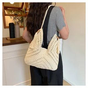 Handmade hollow crochet shoulder tote bag with cute tassels and stylish design for women.