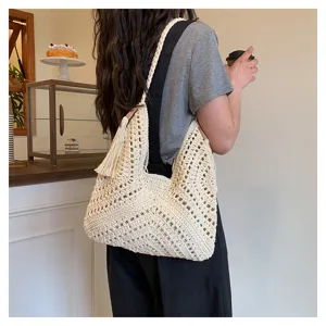 Detailed view of beige crochet hollow-out shoulder tote bag for women vacation style.
