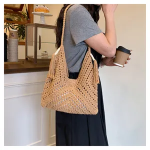 Detailed shot of a beige hollow crochet shoulder tote bag, ideal for casual and beach wear.