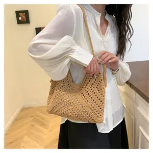 Woven hollow-out shoulder bag detail, elegant beige straw tote for beach vacation and commute.