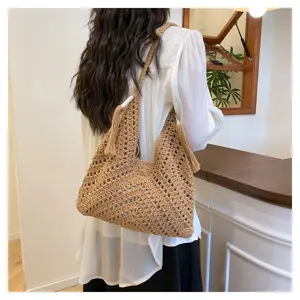 Handmade crochet hollow shoulder bag, casual straw tote for women beach vacation style.