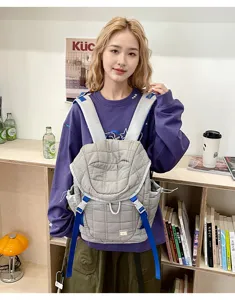 Gros plan détaillé du sac à dos matelassé gris élégant dans un décor de studio moderne.