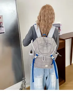 Vue détaillée du sac à dos gris matelassé tendance avec de superbes bretelles bleues.