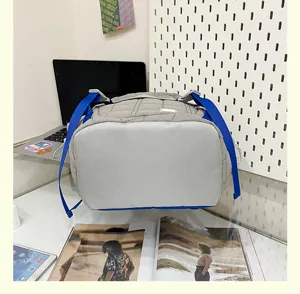 Sac à dos matelassé gris avec bretelles bleues, grande capacité, style tendance.