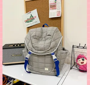 Sac à dos matelassé gris tendance avec bretelles bleues, grande capacité scolaire.