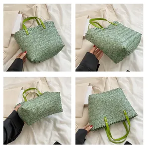 Detailed view of light green woven straw tote bag with bright green handles and metal rivets.