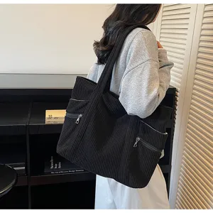 Detailansicht der schwarzen Cord Shopper Tasche mit grossem Volumen und praktischen Taschen.