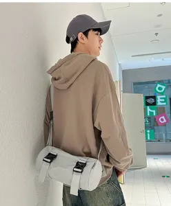 Detailed view of the casual grid barrel crossbody bag worn by model in hallway setting.