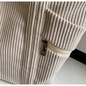 Detailansicht der beigen Kordtasche mit weicher Textur und Metalltasche mit Reißverschluss.