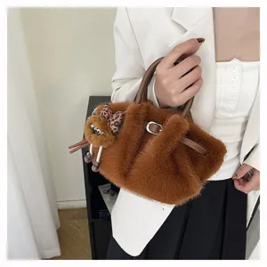 Cozy winter brown plush bucket bag with cute charm, soft faux fur handbag for stylish women.