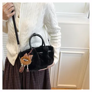 Chic black plush bucket bag with cute furry charm, soft faux fur shoulder bag for women.