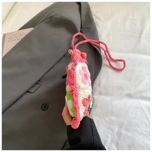 Primo piano di un dettaglio di piccola borsa con fiori all'uncinetto, consistenza fine.
