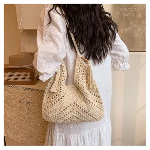 Beige woven straw shoulder bag detail featuring hollow-out pattern and stylish side tassels.
