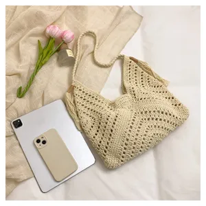 Handmade crochet shoulder bag detail showing hollow knit texture, casual beach handbag.