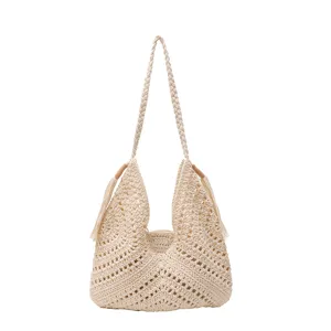 Close-up of the handmade crochet hollow detail on the beige knit beach tote bag.