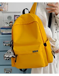 Yellow large capacity school backpack detail, casual canvas bookbag with cute octopus pendant.