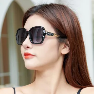Lunettes de soleil polarisées élégantes pour femmes avec monture géométrique et branches chics.