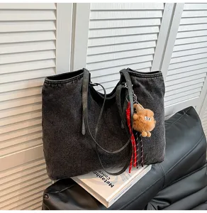 Λεπτομερης οψη vintage μαυρης τσαντας denim tote με χαριτωμενο βελούδινο κρεμαστό.