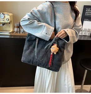 Λεπτομερεια τσάντας shopper denim vintage με λουρι ωμου και βελούδινο κρεμαστο στο καφε.