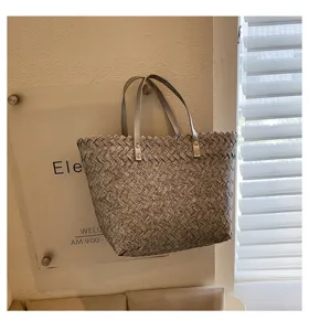 Detailed shot of the woven tote bag hanging against a textured wall with acrylic sign.